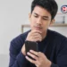 Ilustrasi seseorang menggunakan smartphone untuk mencari aplikasi penghasil uang.